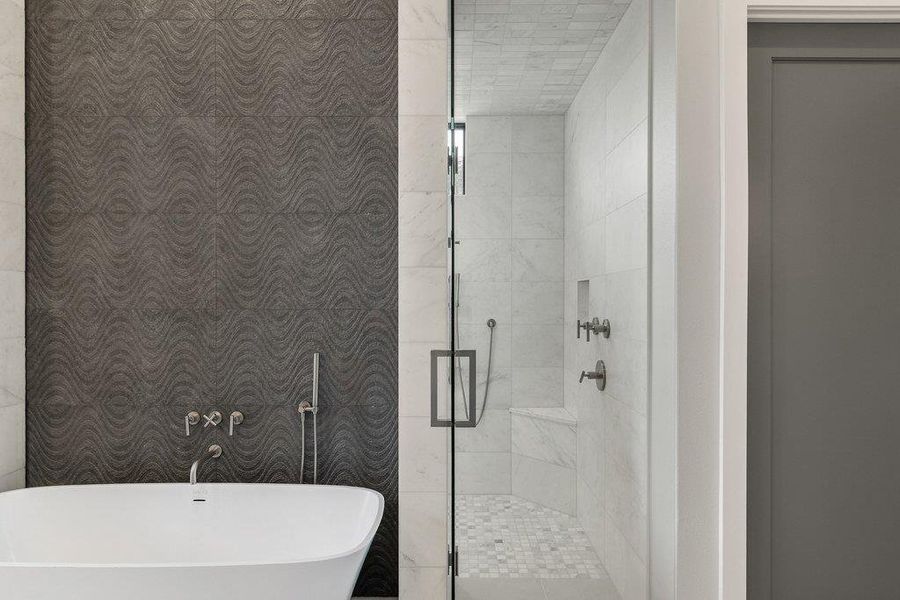 Freestanding soaking tub set against a textured accent wall