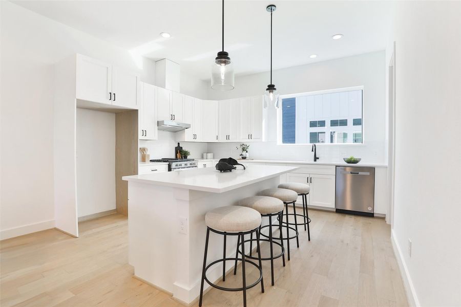 Elegant white quartz countertops complement a bright, all-white kitchen, creating a sleek and contemporary feel. The kitchen island comfortably accommodates 4 barstools.