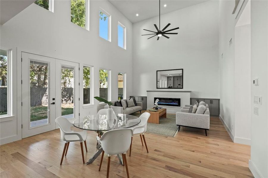 Dining space featuring light wood-type flooring, high vaulted ceiling, and a healthy amount of sunlight