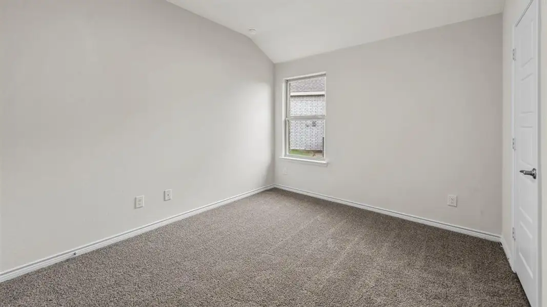 Neutral-toned room featuring a single window, textured walls, and grey carpeting