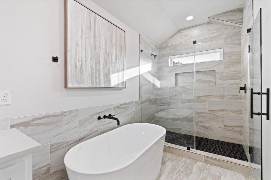 A stunning walk-in shower and freestanding soaking tub bring a high-end, resort-style feel right into your home. With beautiful tilework and an open, airy design, this bathroom is built for relaxation and comfort.