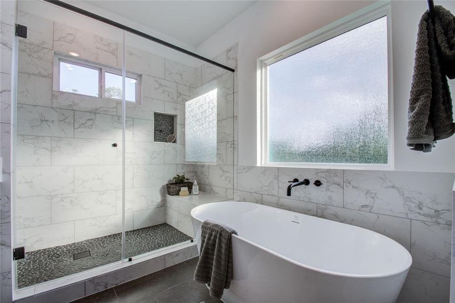 The primary bathroom has both a freestanding tub and a separate shower! Model home photos, finishes and floor plan MAY VARY!