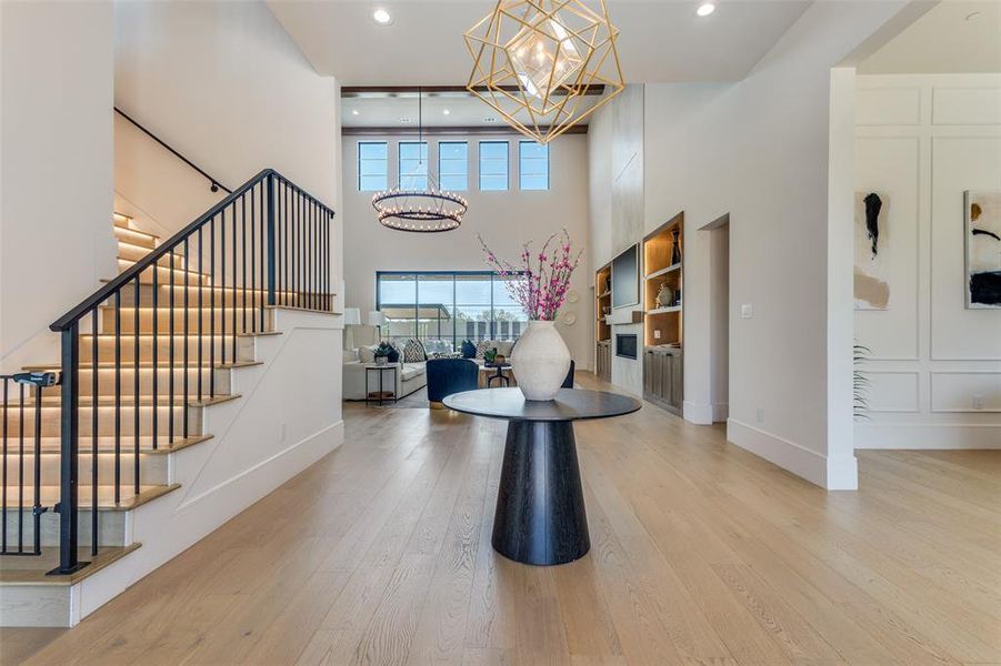 Foyer entrance featuring a high ceiling, hardwood / wood-style flooring, and a notable chandelier