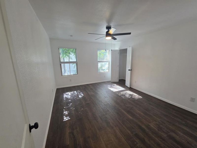 Empty room with dark wood finished floors and ceiling fan Empty room with dark wood finished floors and ceiling fan