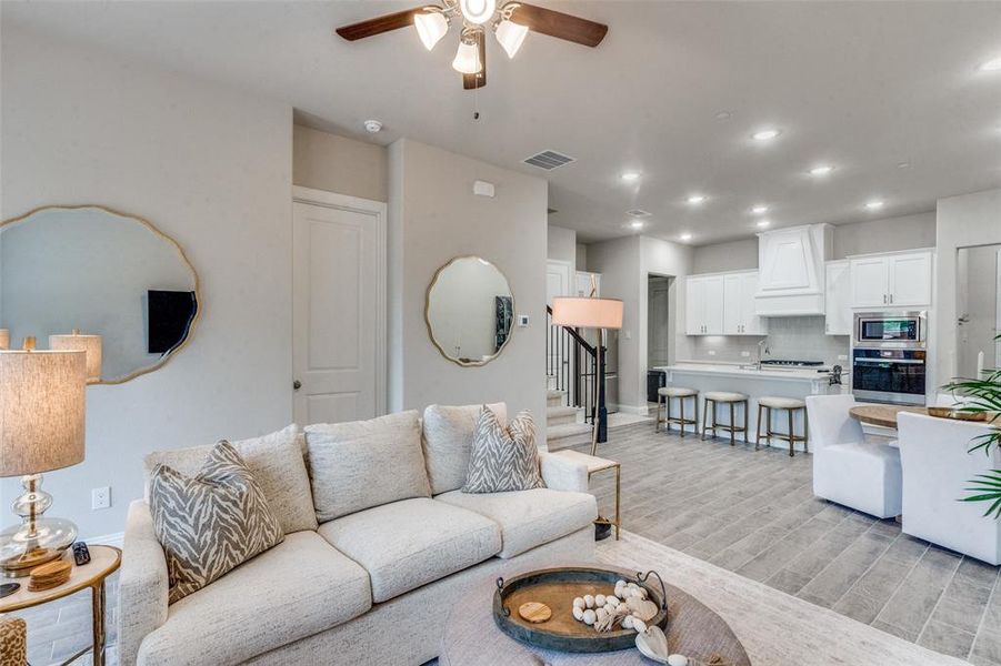 Living room with ceiling fan and light wood-type flooring