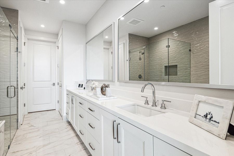 Primary bathroom featuring dual sinks, gorgeous quartz counter-top, glass-framed walk-in shower with shower seat, soaking tub, linen closet and a huge walk-in dressing room. Photos are of a similar unit with the same floor plan