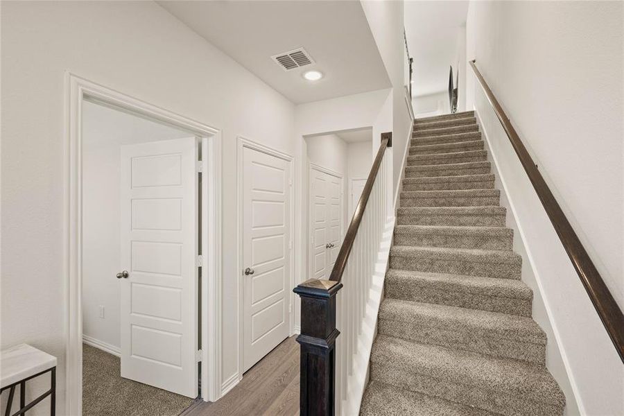 Staircase featuring hardwood / wood-style flooring