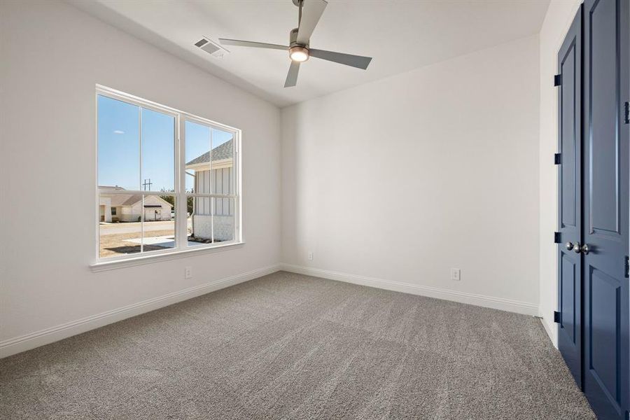 Spare room with a ceiling fan, carpet, visible vents, and baseboards