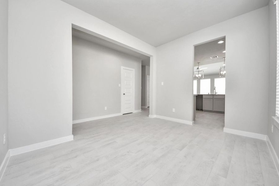 Make memories gathered around the table with your family and friends! This spacious dining room features elegant flooring, custom paint, and adjacent to family room and kitchen for open concept feel. Sample photo of completed home with similar floor plan. Actual colors and selections may vary.
