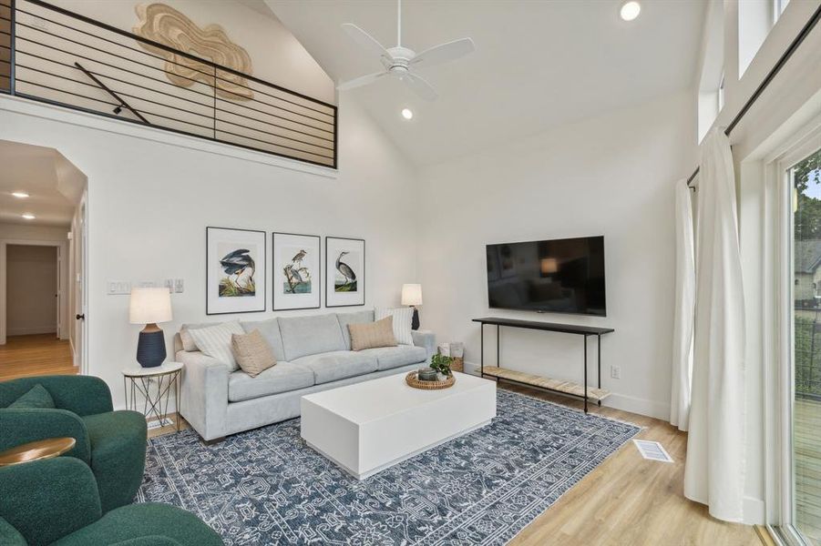 Living room featuring high vaulted ceiling, wood-type flooring, and ceiling fan
