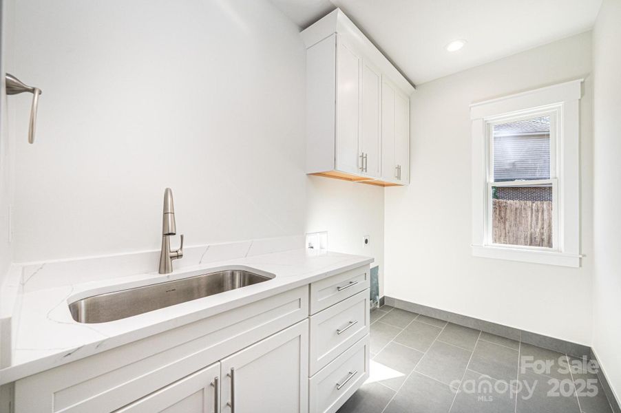 Main Level Laundry complete with overhead cabinets and Full size Sink and Cabinets Main Level Laundry complete with overhead cabinets and Full size Sink and Cabinets