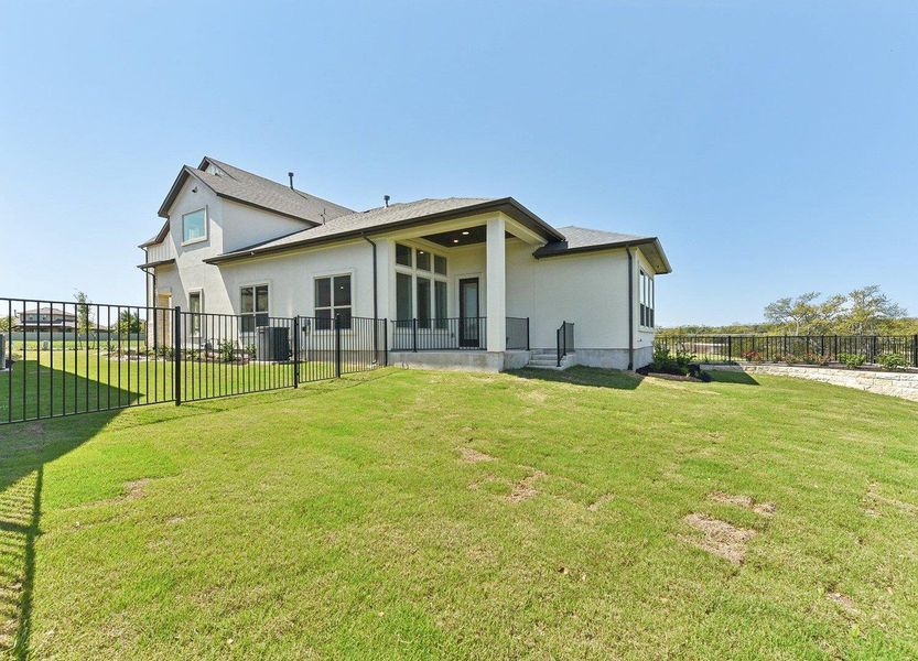 Rear view of property featuring stucco siding, fence, and a lawn Rear view of property featuring stucco siding, fence, and a lawn