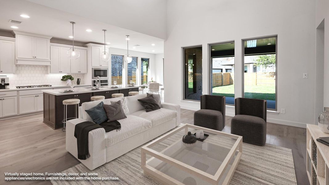 Living area with light wood finished floors, recessed lighting, and a high ceiling Living area with light wood finished floors, recessed lighting, and a high ceiling