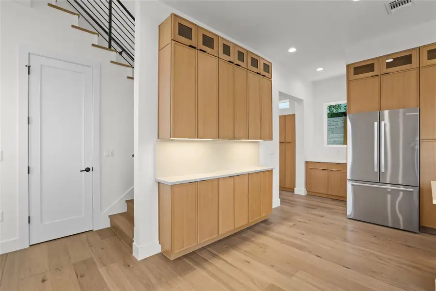 Blonde wood cabinetry offers abundant storage in this functional and inviting kitchen space.