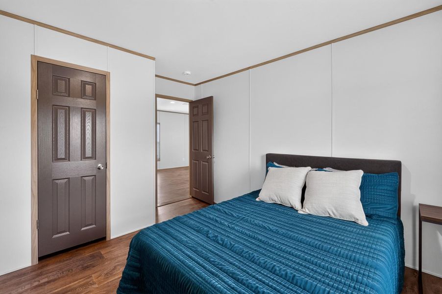 Comfortable sleeping quarters await, featuring durable wood flooring and ample space.