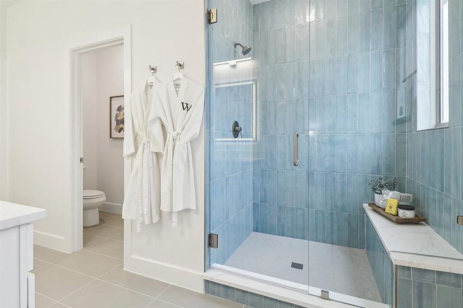 Full bathroom featuring tile patterned flooring, baseboards, a shower stall, and toilet