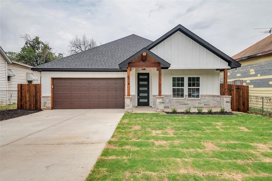 View of front of home with a garage and a front yard