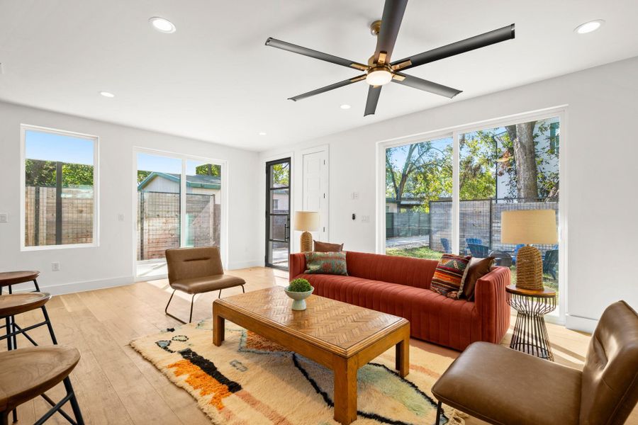 Light-filled living area with recessed lighting, light wood-style floors, and a ceiling fan Light-filled living area with recessed lighting, light wood-style floors, and a ceiling fan