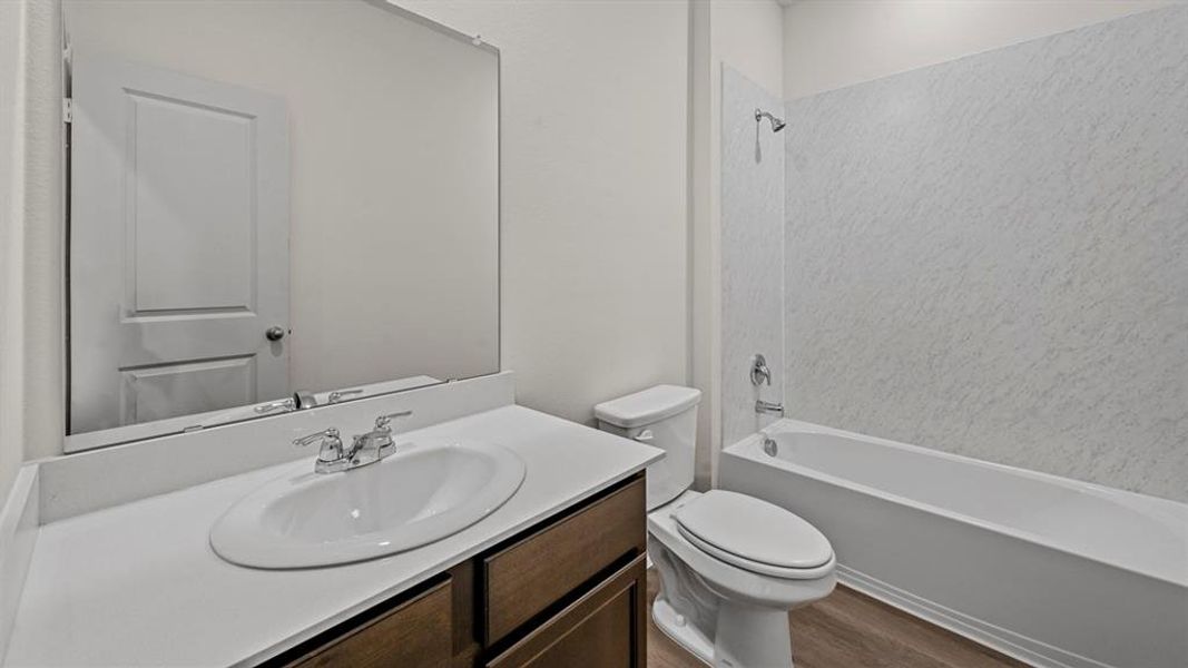 Full bathroom featuring a single vanity with an oval undermount sink, chrome faucet, and white countertop