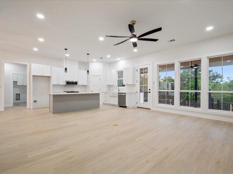 Open concept living area with light-colored flooring, recessed lighting, and a ceiling fan