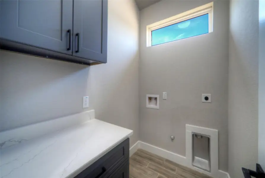 High clerestory windows bring natural light into this functional utility space featuring solid stone countertops. High clerestory windows bring natural light into this functional utility space featuring solid stone countertops.
