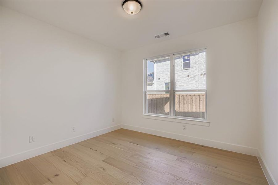 Empty room with light wood finished floors and baseboards Empty room with light wood finished floors and baseboards