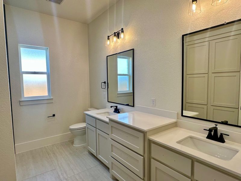 Full bathroom with plenty of natural light, a textured wall, and vanity