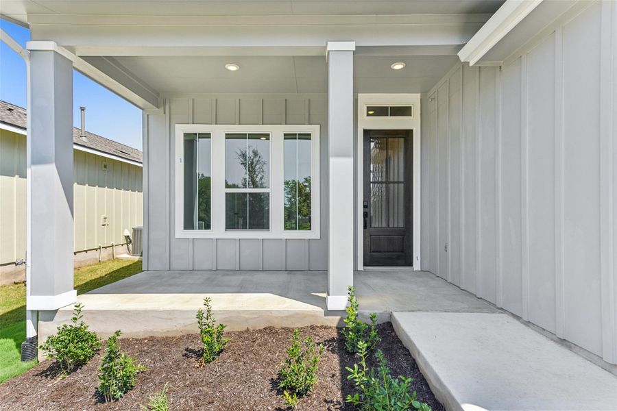 Property entrance with board and batten siding and a porch Property entrance with board and batten siding and a porch