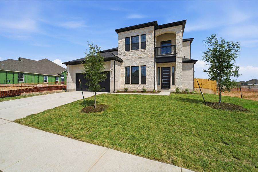 Front exterior of a new home in Sunfield, Buda, TX, highlighting curb appeal (Image 2). Front exterior of a new home in Sunfield, Buda, TX, highlighting curb appeal (Image 2).