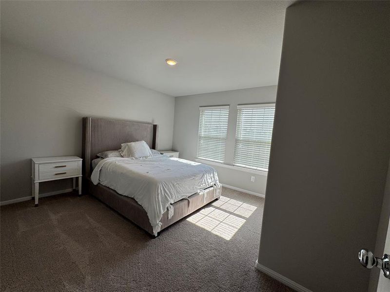 Carpeted room with a recessed ceiling light and two windows featuring horizontal blinds Carpeted room with a recessed ceiling light and two windows featuring horizontal blinds