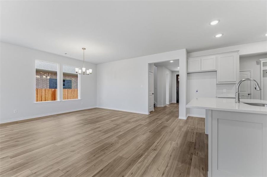 Unfurnished dining area featuring light wood finished floors, a chandelier, and recessed lighting