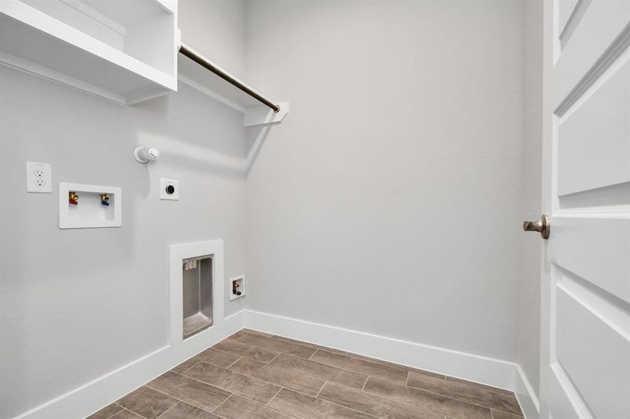 A perfect blend of functionality and comfort. Laundry room, thoughtfully equipped with shelving for effortless organization. Both gas and electric connections available. Sample photo of completed home with similar plan. As built color and selections will vary.