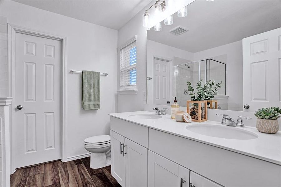 Bathroom featuring a double vanity with white cabinetry, light countertops, and chrome faucets