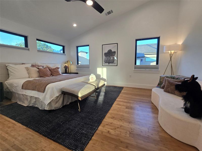 High vaulted ceilings and rich wood floors anchor this architectural bedroom space.