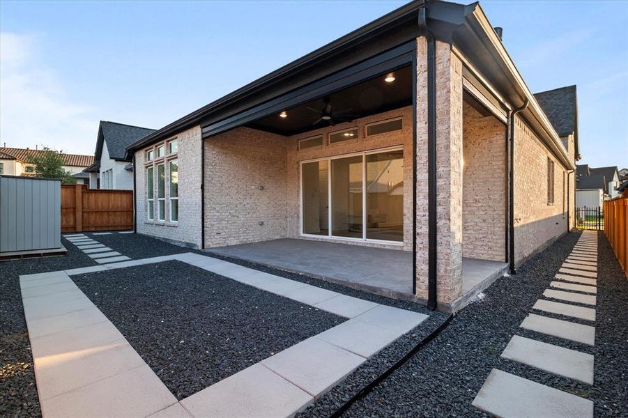 Back of house with a fenced backyard, a ceiling fan, a patio, brick siding, and a gate Back of house with a fenced backyard, a ceiling fan, a patio, brick siding, and a gate