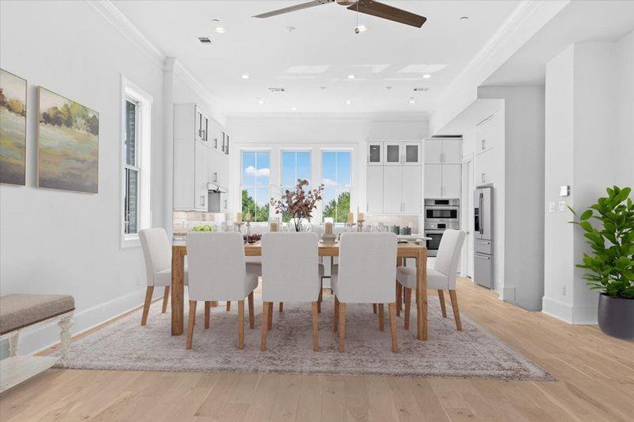 Dining space with light wood finished floors, crown molding, recessed lighting, and ceiling fan