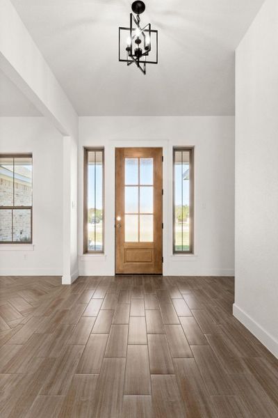 Foyer featuring wood tiled floors and a chandelier