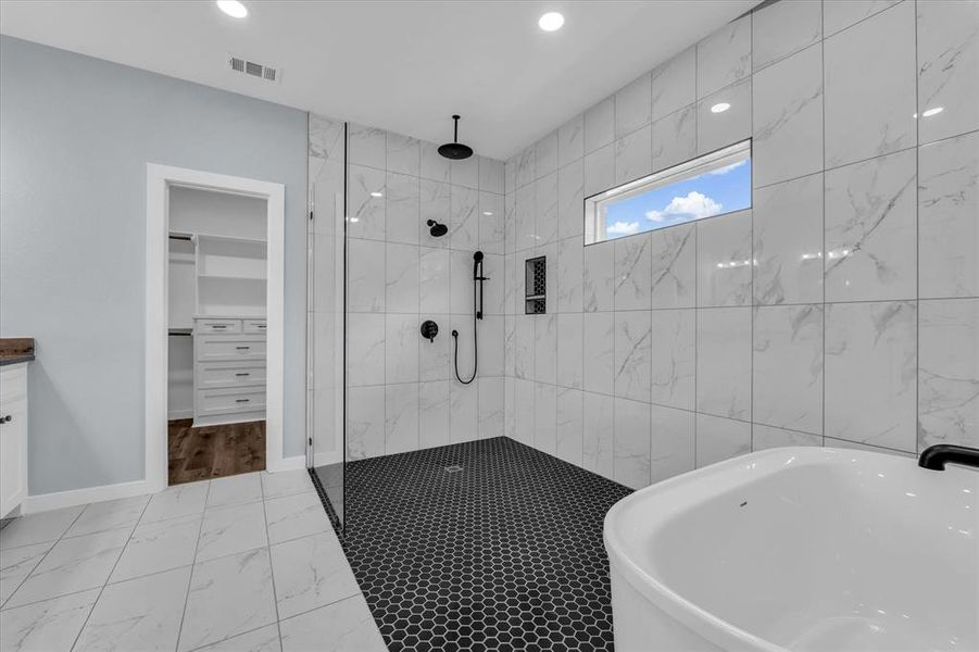 Bathroom featuring a freestanding tub, a marble finish shower, vanity, light marble finish flooring, and recessed lighting Bathroom featuring a freestanding tub, a marble finish shower, vanity, light marble finish flooring, and recessed lighting