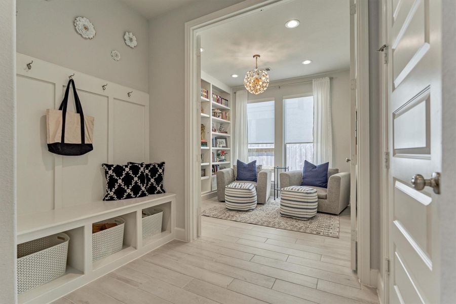 Mud Room just inside the garage entry with hooks, bench & cubbies. Durable, stylish flooring extends throughout the main living spaces into the primary bedroom