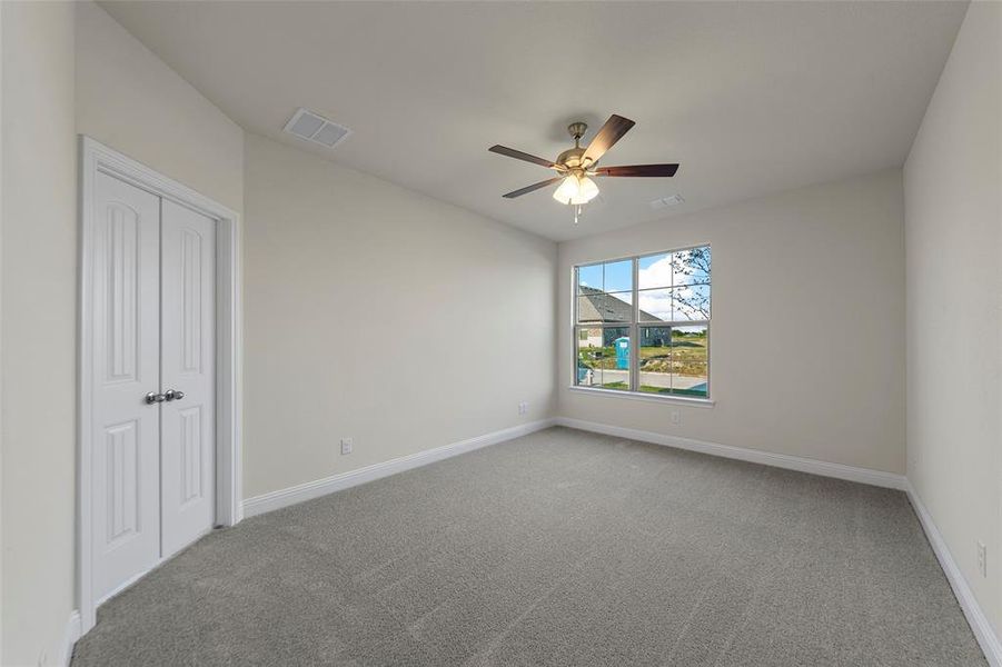 Unfurnished bedroom with light carpet, a ceiling fan, and a closet Unfurnished bedroom with light carpet, a ceiling fan, and a closet
