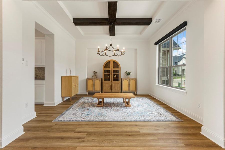 Dining space featuring coffered ceiling, beamed ceiling, a chandelier, and wood finished floors Dining space featuring coffered ceiling, beamed ceiling, a chandelier, and wood finished floors
