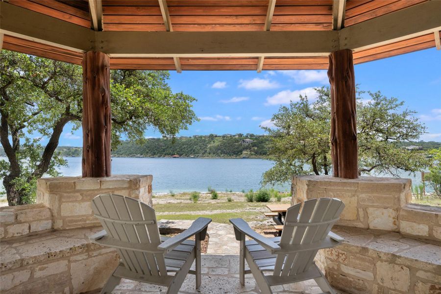 A tranquil lakeside retreat with a covered patio beckons relaxation amidst nature's beauty. A tranquil lakeside retreat with a covered patio beckons relaxation amidst nature's beauty.