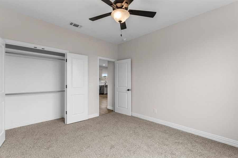 Unfurnished bedroom featuring ceiling fan, a closet, and carpet Unfurnished bedroom featuring ceiling fan, a closet, and carpet