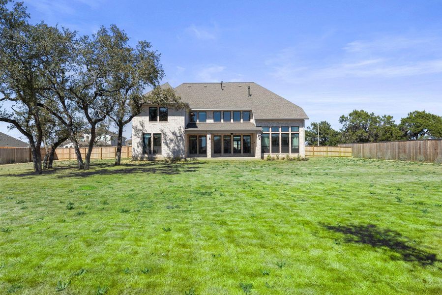 Back of property with a yard, a fenced backyard, and a sunroom