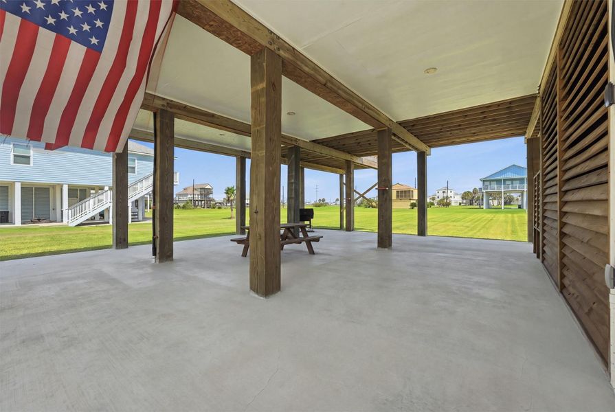 Spacious covered patio area with sturdy wood beams, perfect for outdoor gatherings, overlooking a lush, open lawn. Spacious covered patio area with sturdy wood beams, perfect for outdoor gatherings, overlooking a lush, open lawn.