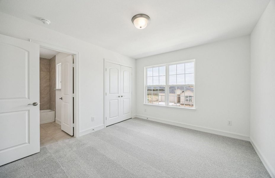 Roomy secondary bedroom with extensive closet storage  *Real home pictured