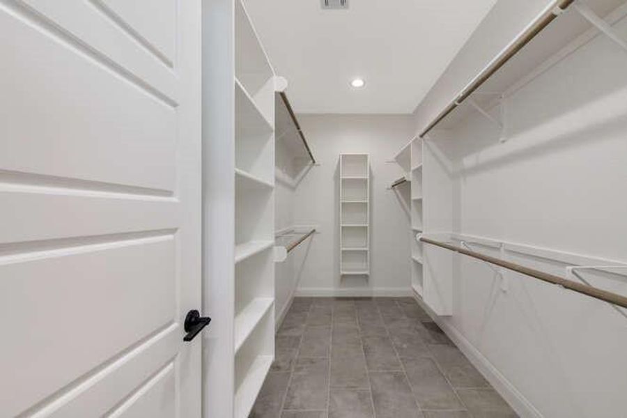 Walk in closet with light tile patterned floors Walk in closet with light tile patterned floors