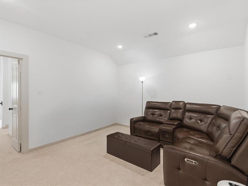 Carpeted room with recessed lighting and a white paneled door