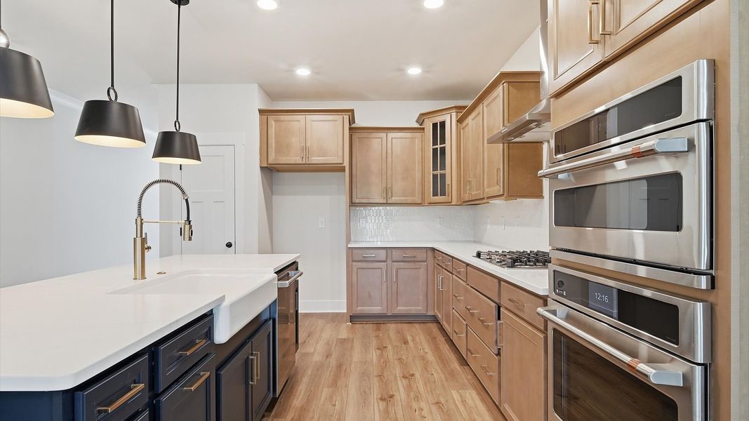 Exceptional kitchen featuring a spacious island, eye-catching pendant lights, and modern finishes at Harrier Point