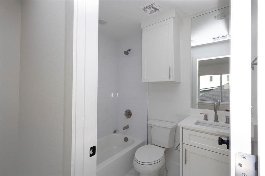 Bathroom featuring visible vents, vanity, toilet, and bathing tub / shower combination